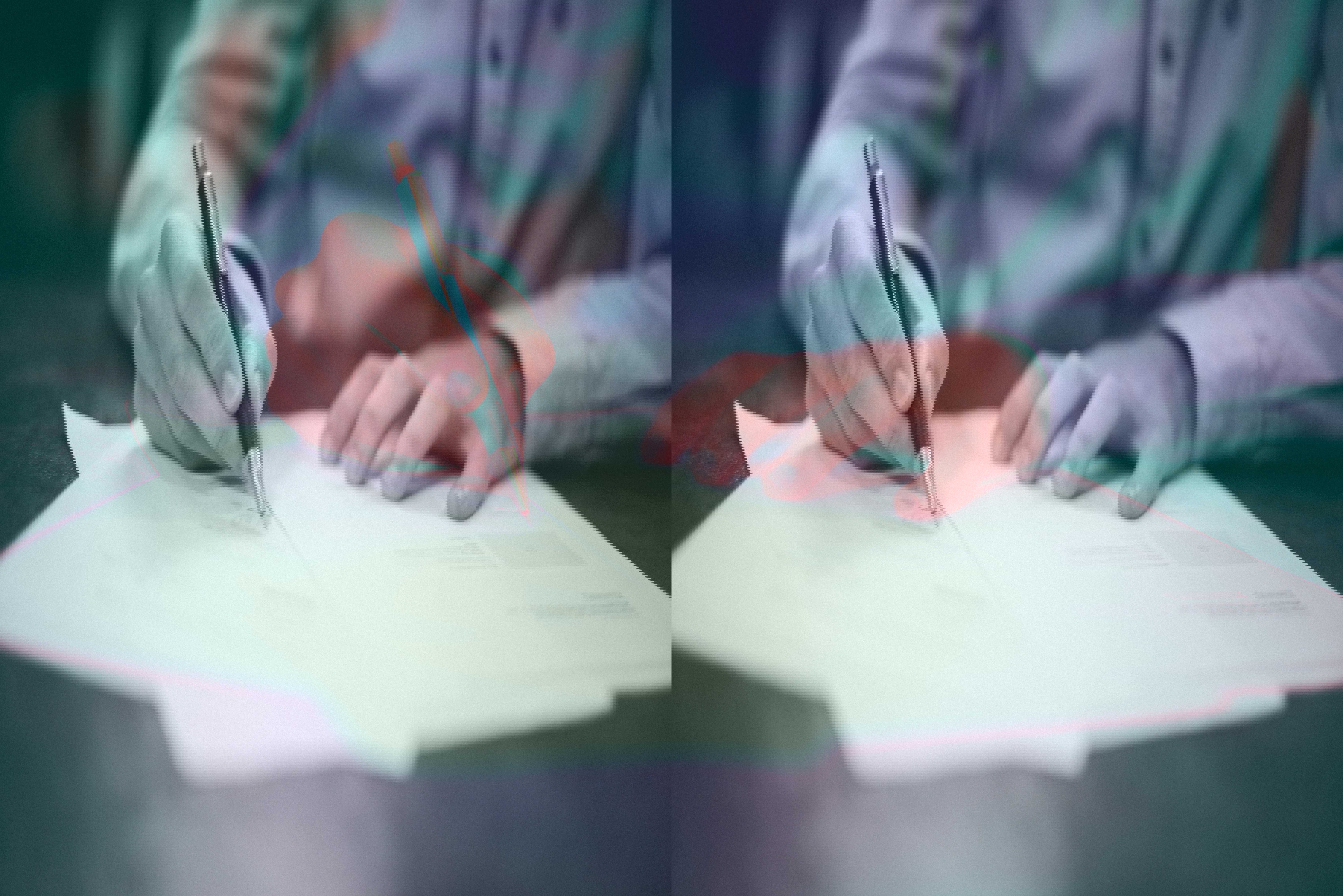 Person underskriver dokument med en kuglepen.