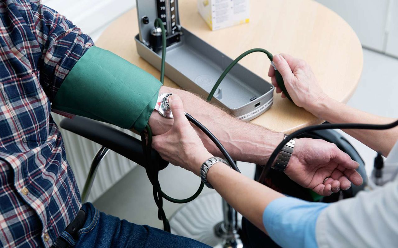 Læge tager blodtrykket på en patient.